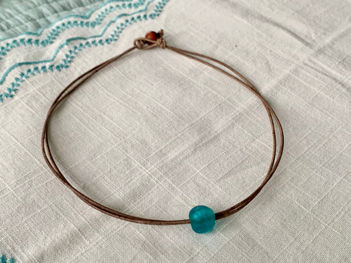 Double strand leather necklace with an aqua glass Ghana bead. toggle closure