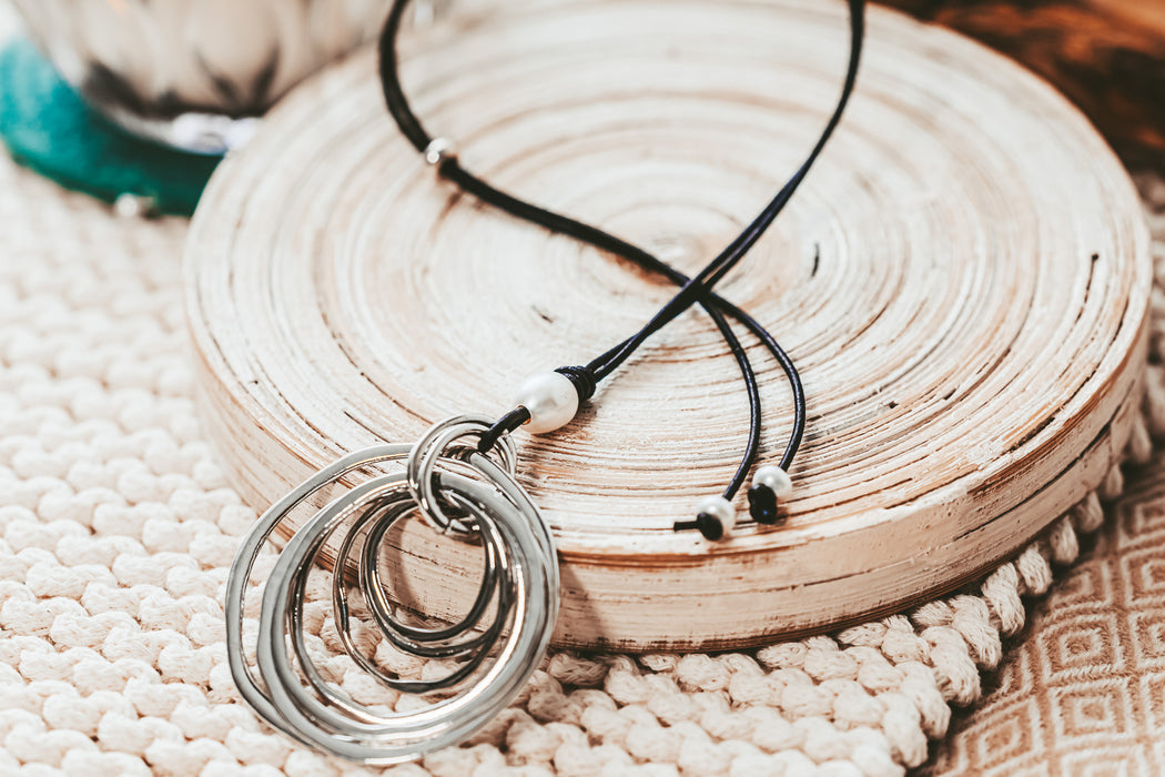 silver multi ring pendant on adjustable leather cord with pearl accent bead