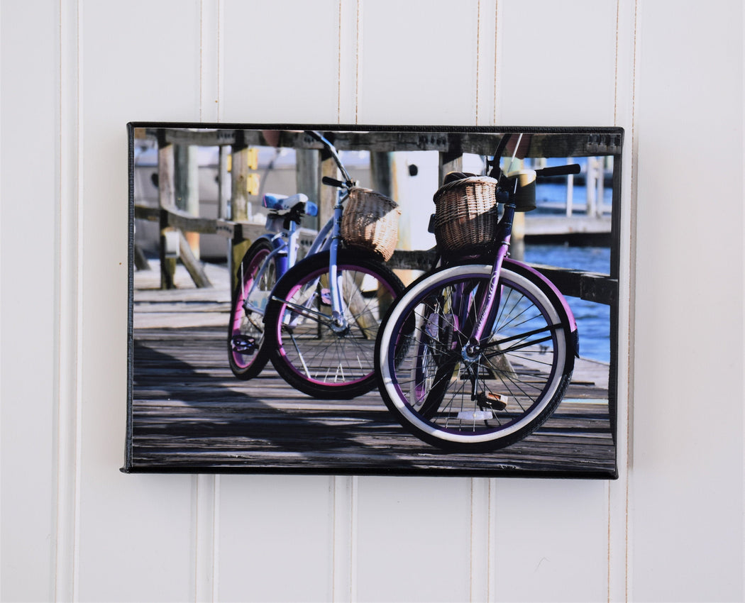 canvas photo of 2 pink bikes leaning against a boardwalk